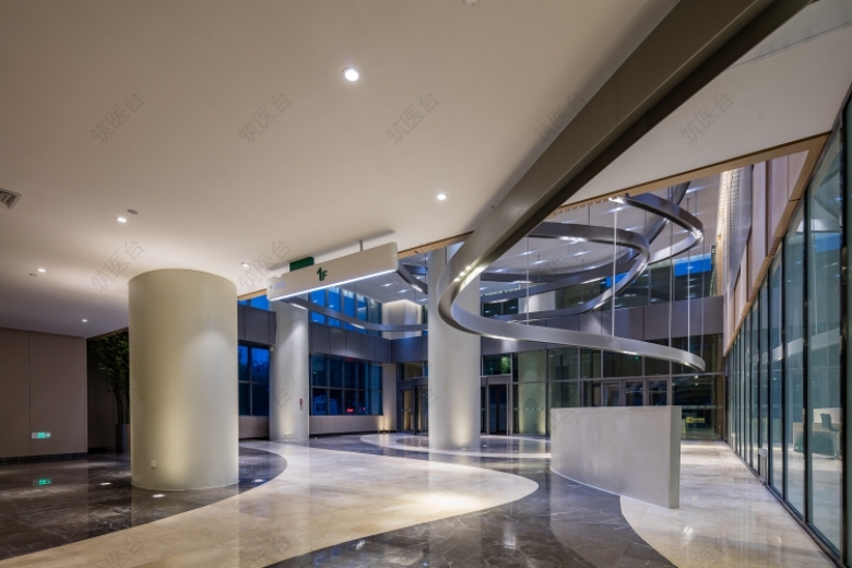 线性空间在一层大厅呈现柔化了两个不同高区域的边界，共享位置的飘带式吊架灯曲线的接待台和半透椭圆形体的等候区，为组成创造了连续的视觉效果，连接及完成了各个区域功能。呈线性划分的编织肌理的地面，景观，景观